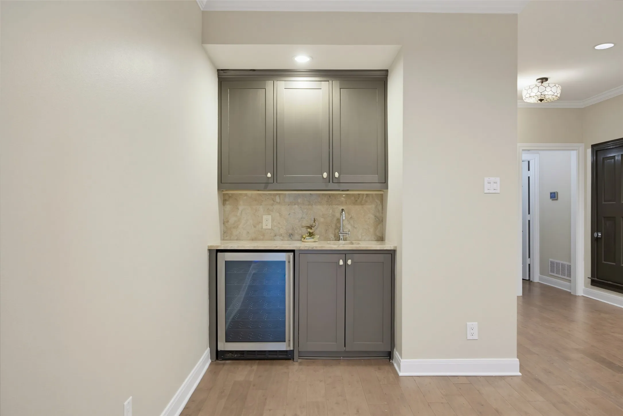 Wet bar with wine fridge and cabinetry in the main living areas