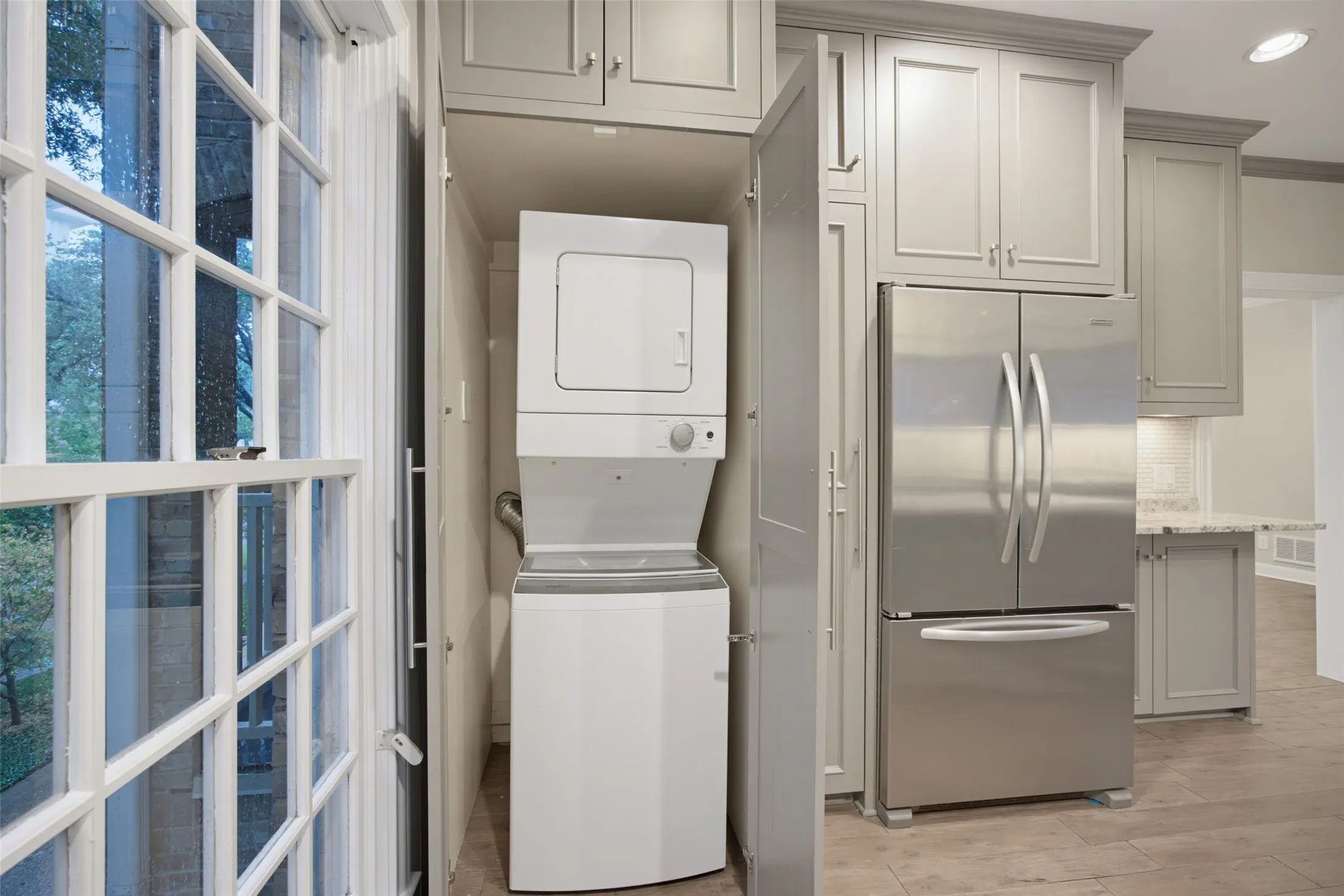 Utility closet in kitchen with stack washer & dryer remaining with home