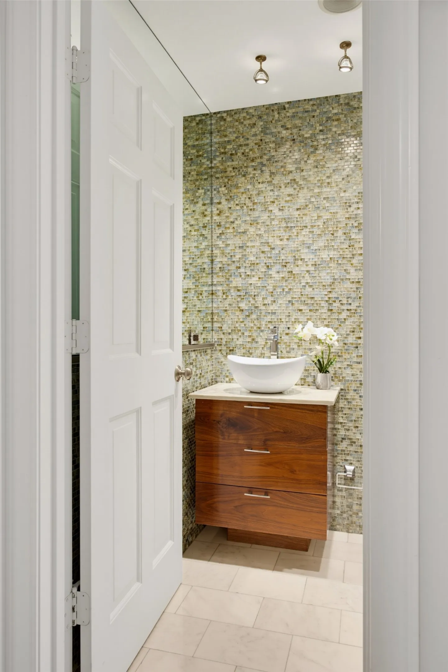 Half bath is modern with tile and marble accents