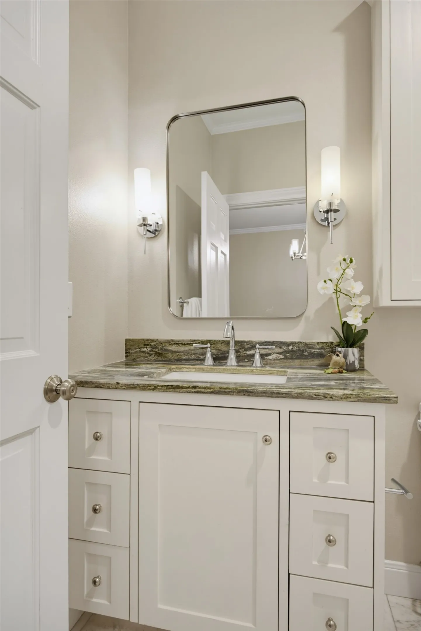 Full bath with marble counters and decorative lighting