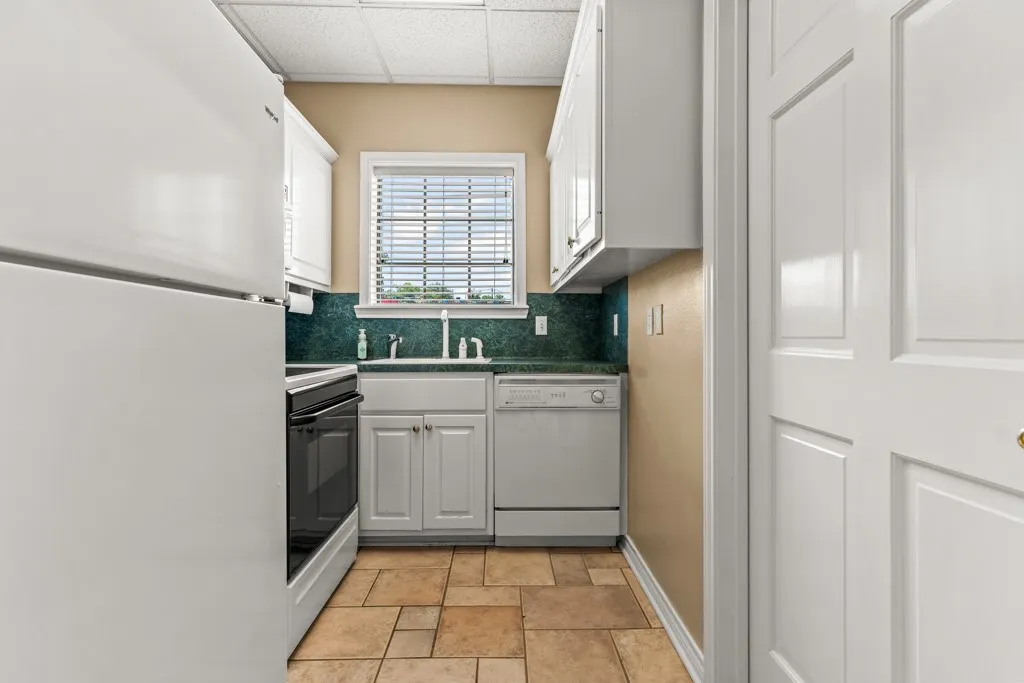 Kitchen featuring white cabinetry, a built-in oven, and tile flooring