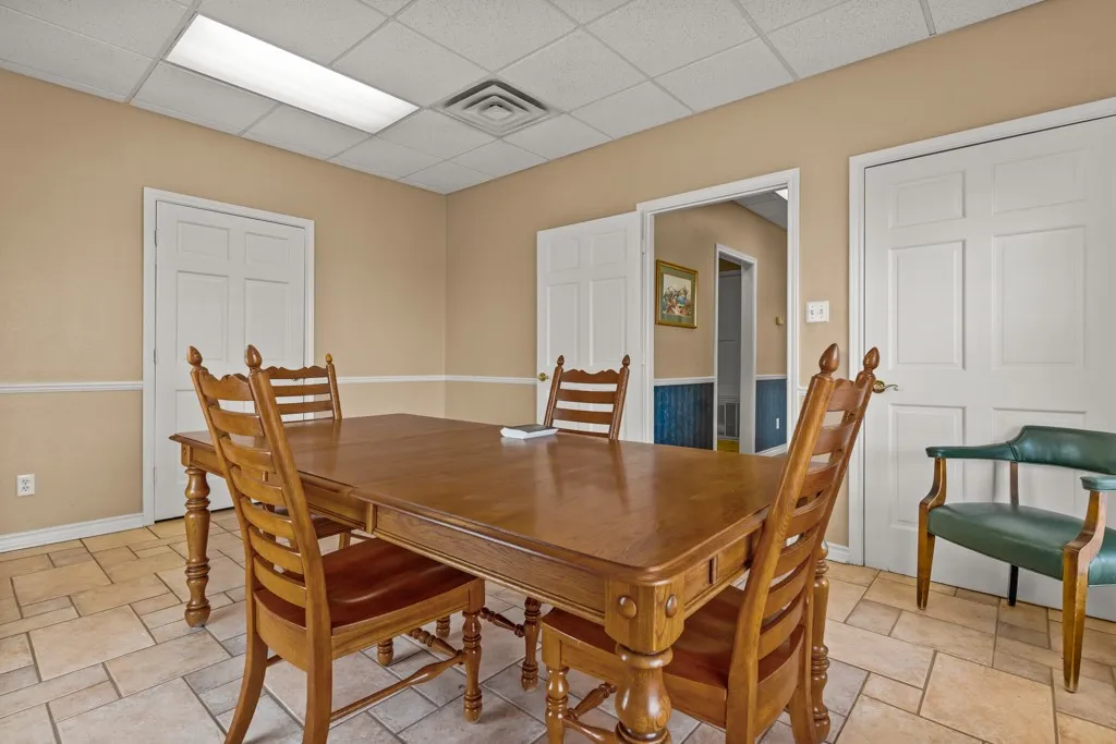 Neutral-toned walls with chair rail molding and durable tile flooring