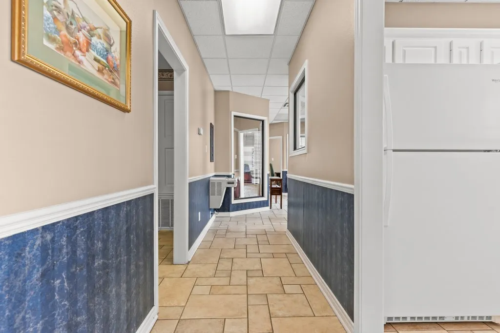 Tiled flooring, paneled wainscoting, recessed lighting, and a built-in refrigerator