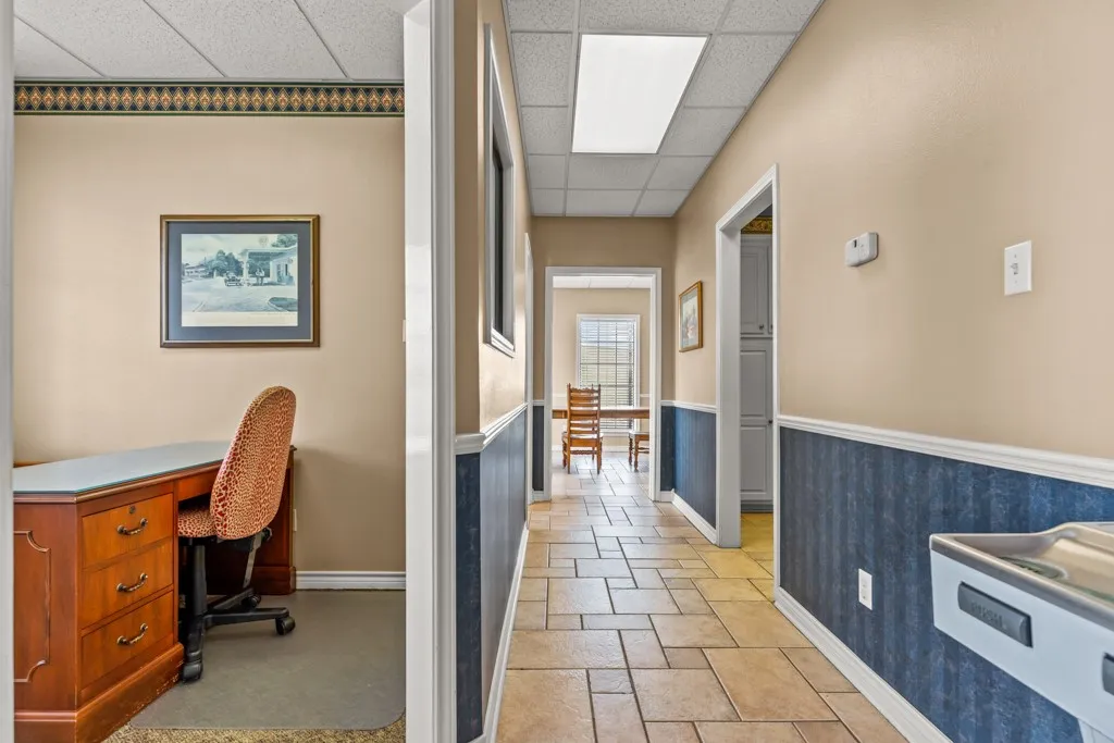 Hallway with tile flooring, chair rail molding, and recessed lighting