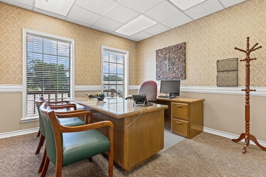 Dual windows with horizontal blinds, decorative wallpaper, white crown molding, light-toned wall paneling, and a drop ceiling with integrated lighting
