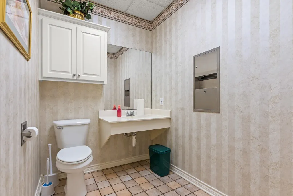 Striped wallpaper accenting a built-in white vanity with integrated sink