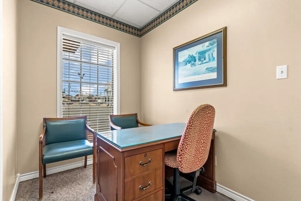 Recessed ceiling with acoustic tiles, neutral wall paint, patterned wallpaper border, and window with horizontal blinds