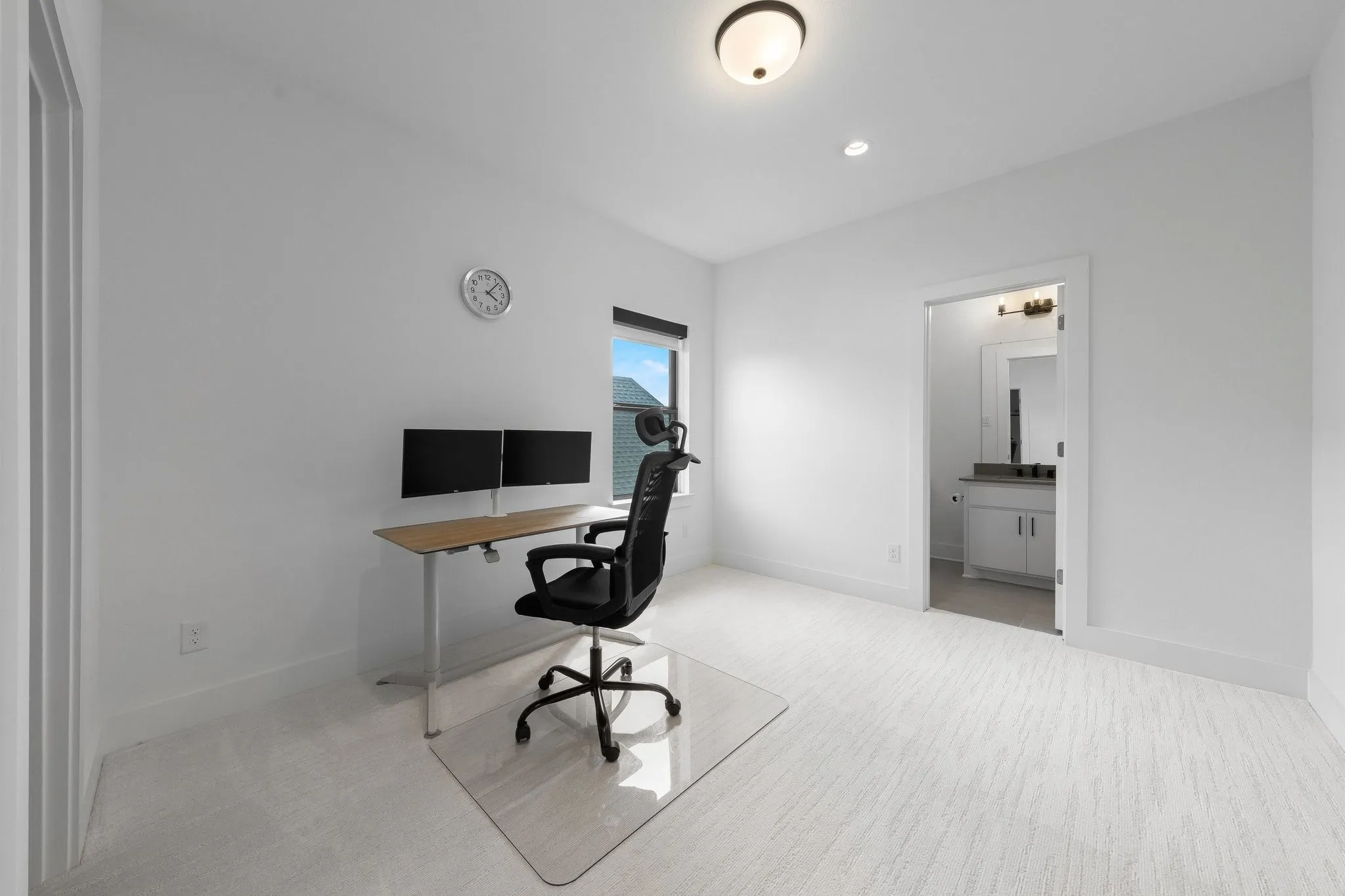 Recessed lighting, wall-mounted light fixture, and window provide illumination