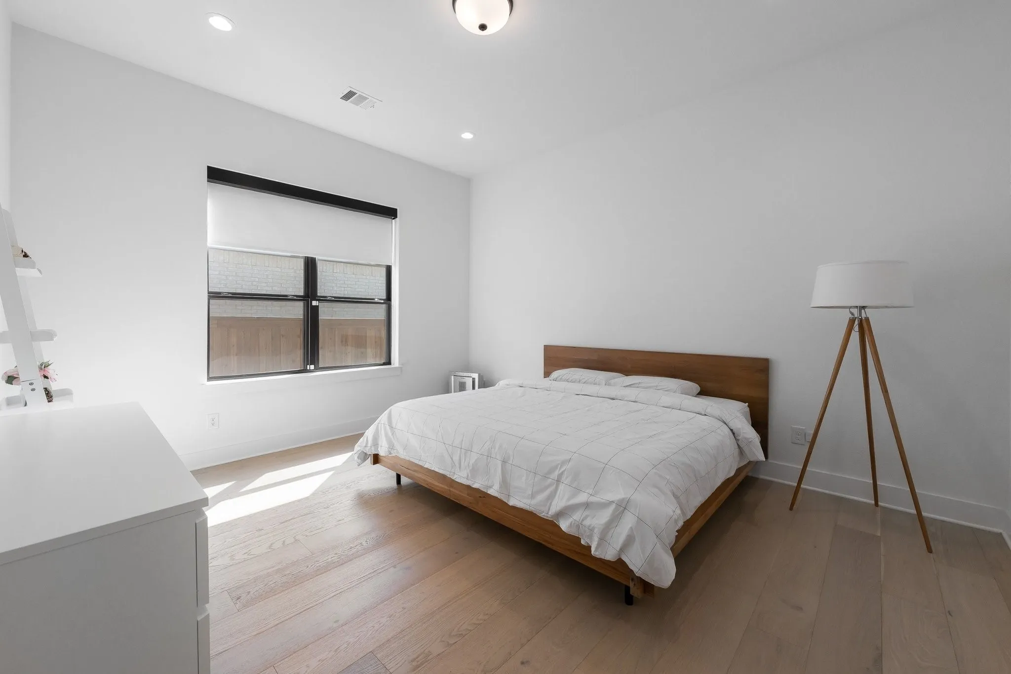 Wood-finish flooring, recessed lighting, and a window with roller shades