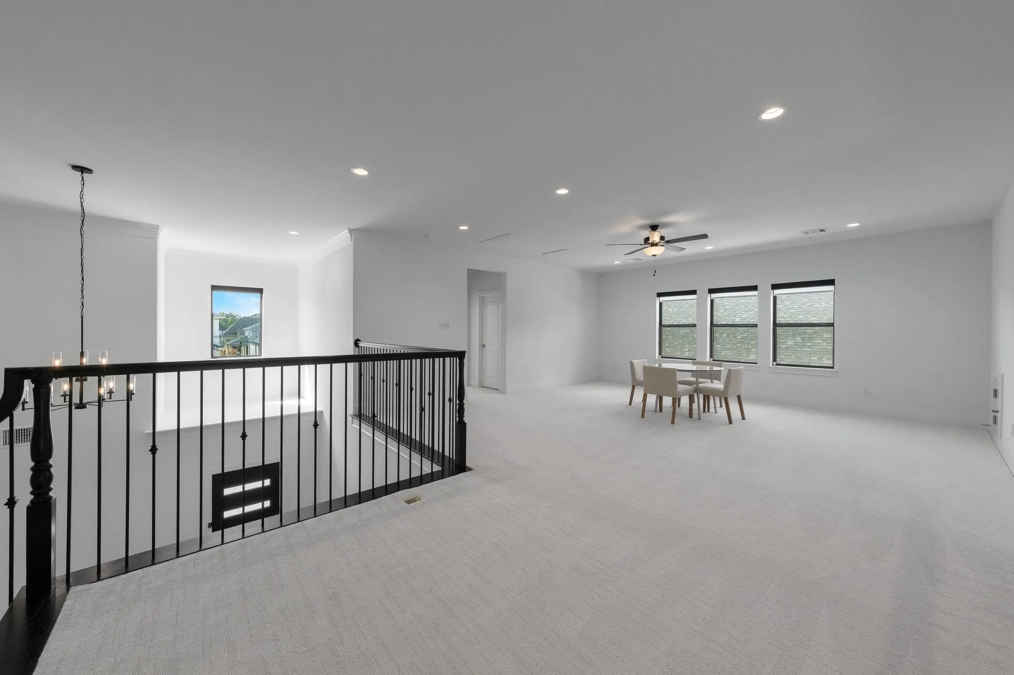 Spacious loft area featuring light-toned carpeting, recessed lighting, and a ceiling fan