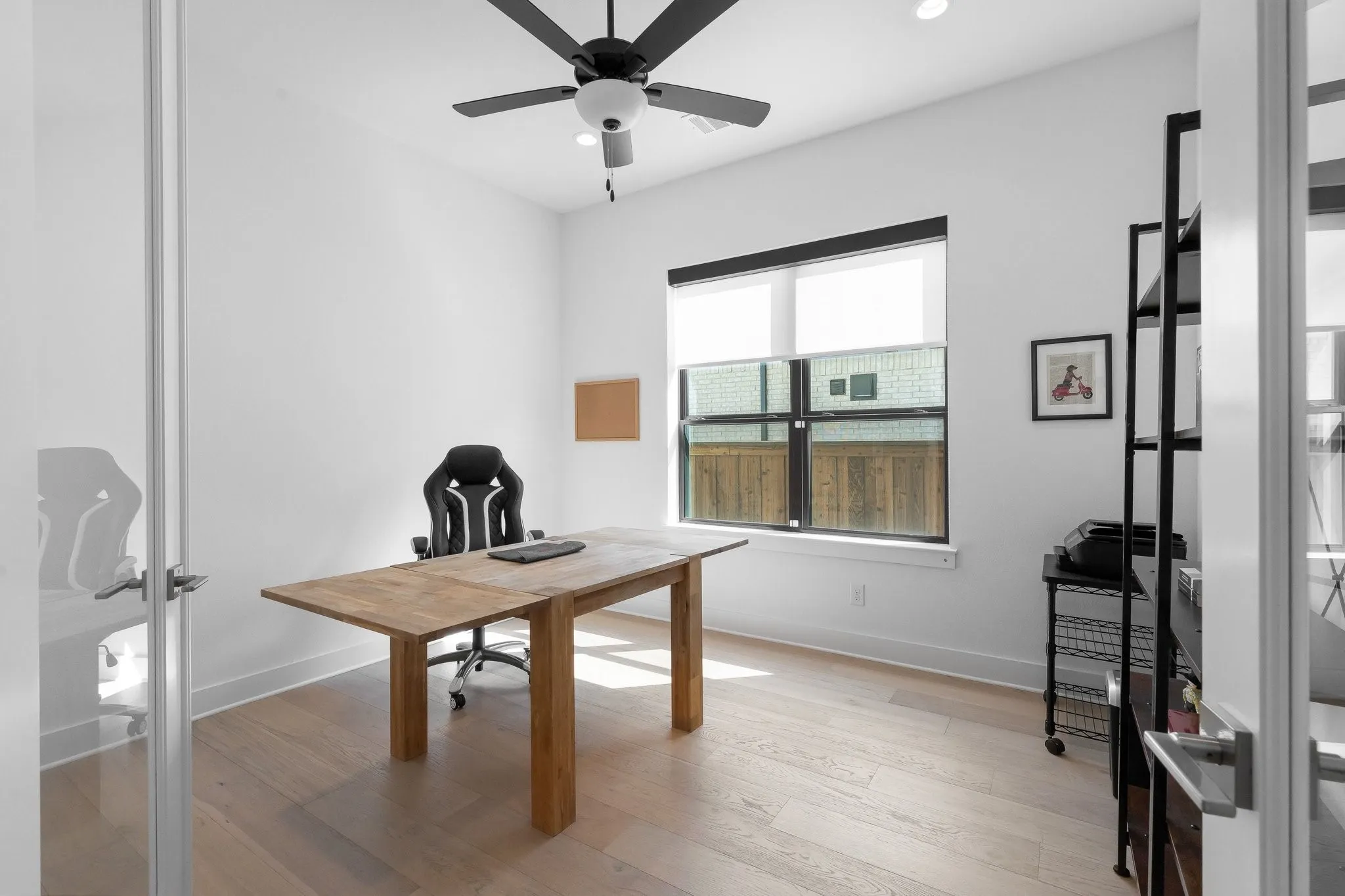 Recessed lighting, wood-finish flooring, ceiling fan, and a large window with roller shades