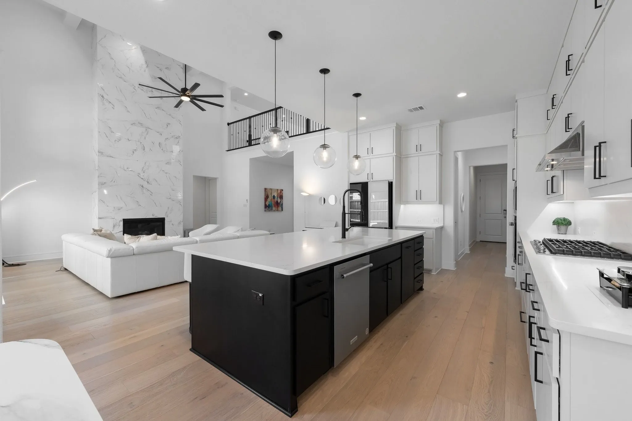 Expansive open-concept living space with light wood-finish flooring