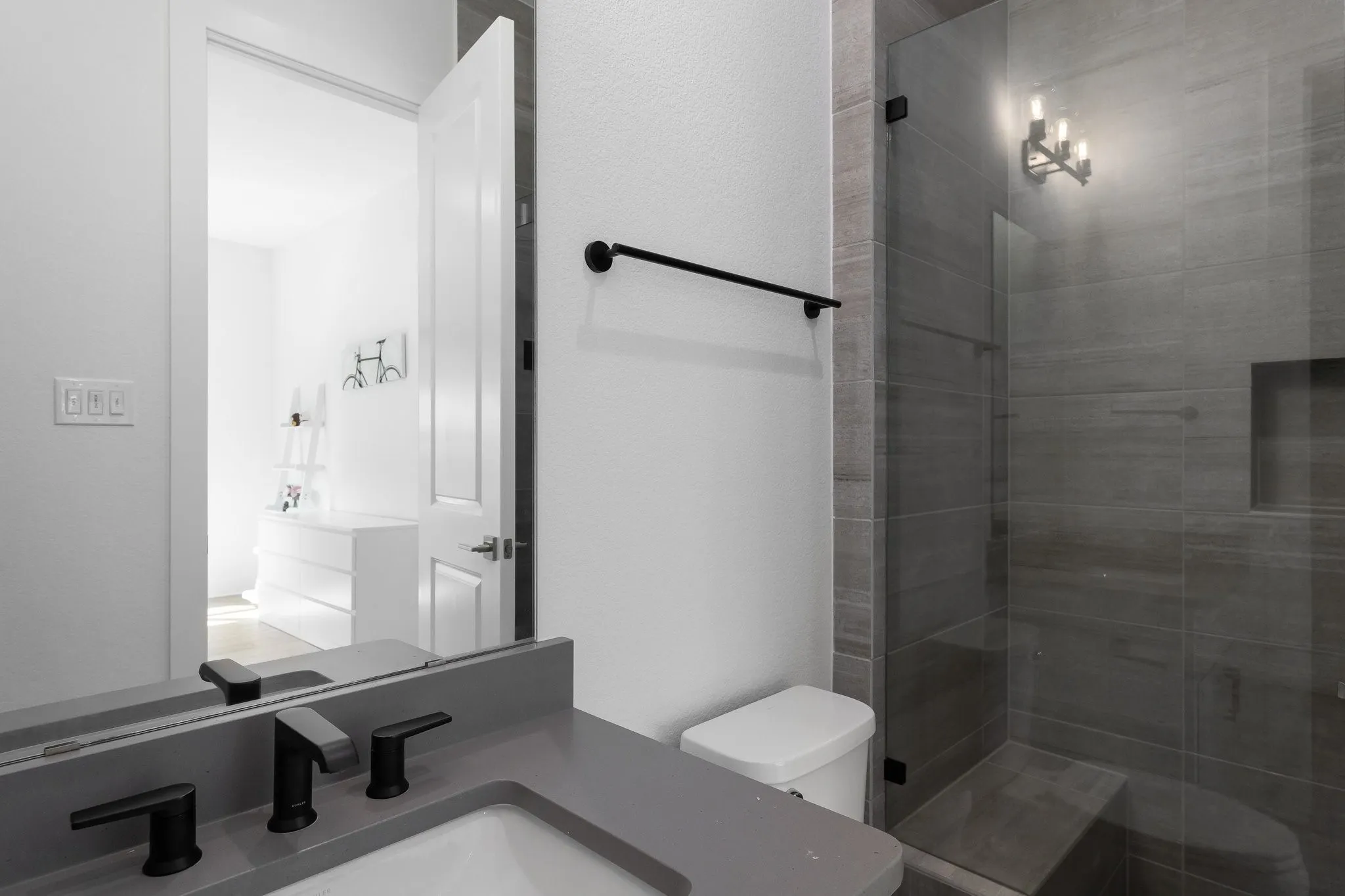 Sleek vanity with a gray countertop and matte black fixtures