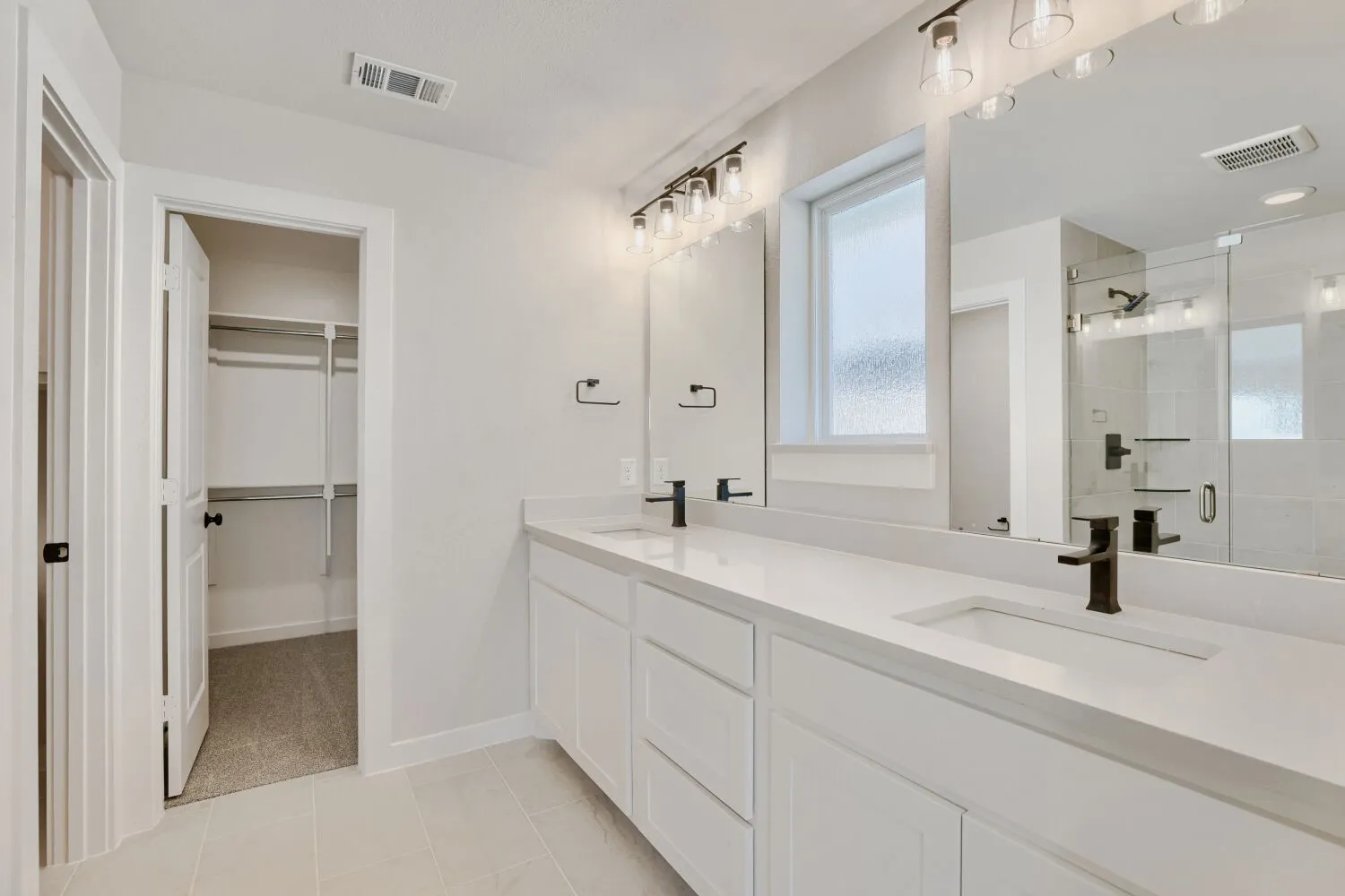 Dual vanity with integrated sinks, white cabinetry, and matte black fixtures