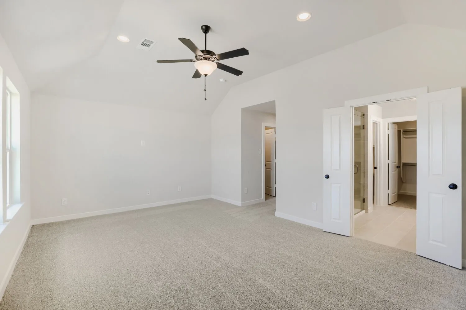Vaulted ceiling with recessed lighting and ceiling fan, light-toned carpet flooring, double doors, and a glass-enclosed shower