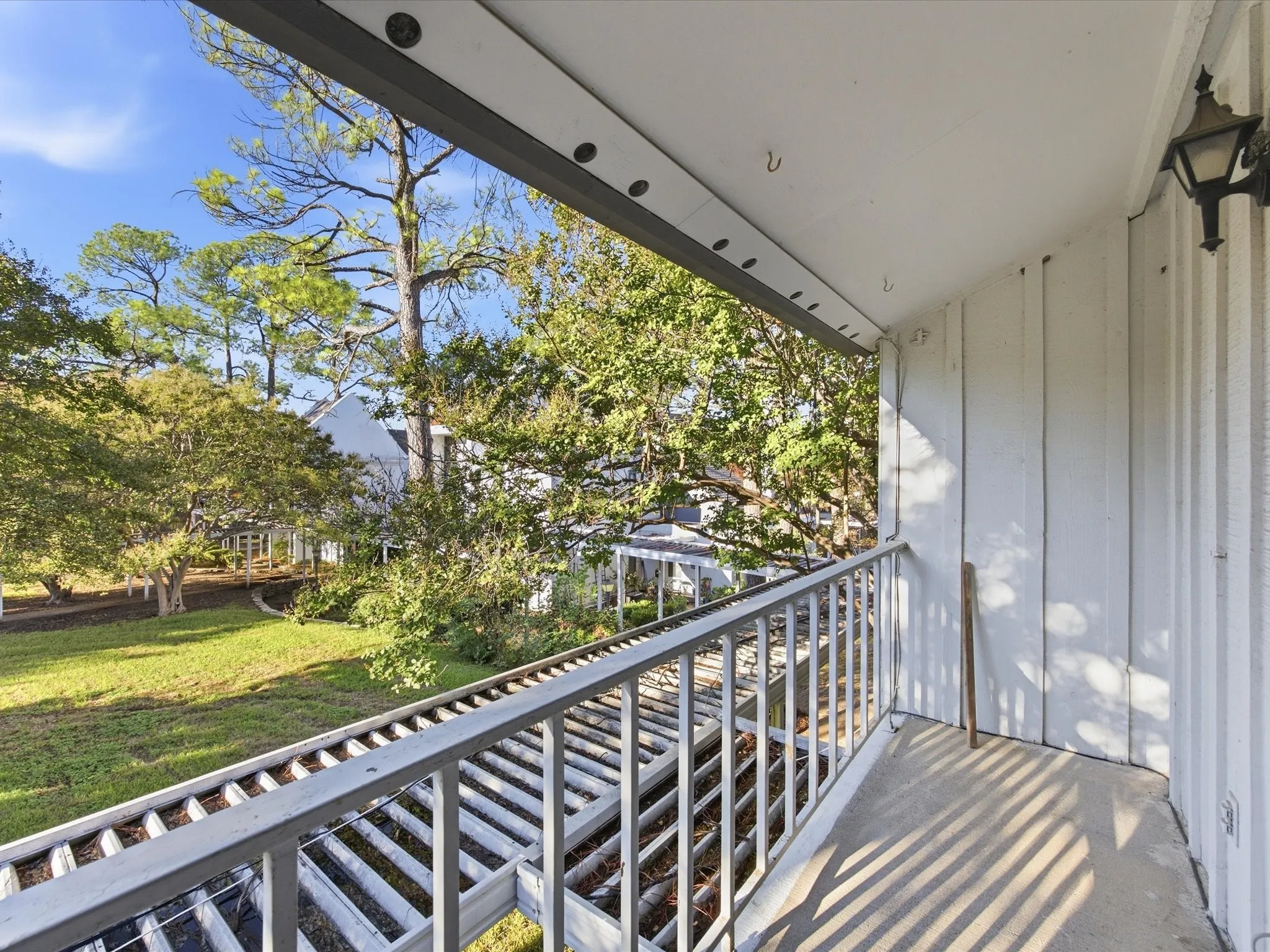 Private balcony with concrete flooring, framed by a metal railing