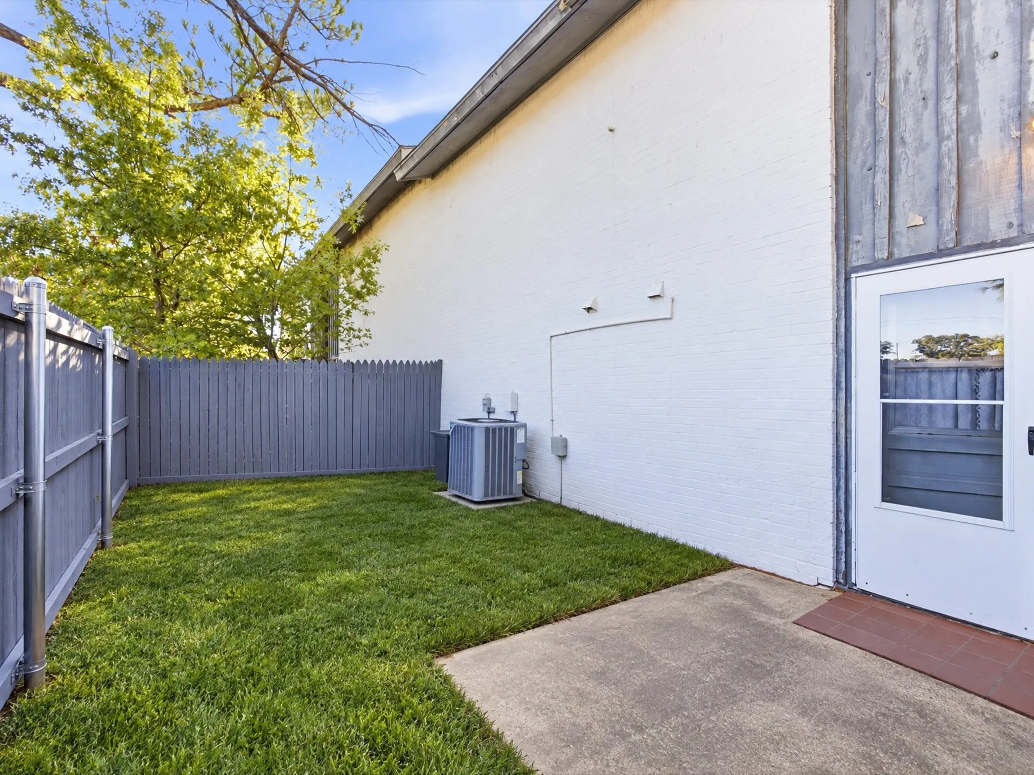Private enclosed yard featuring a concrete patio and painted fencing