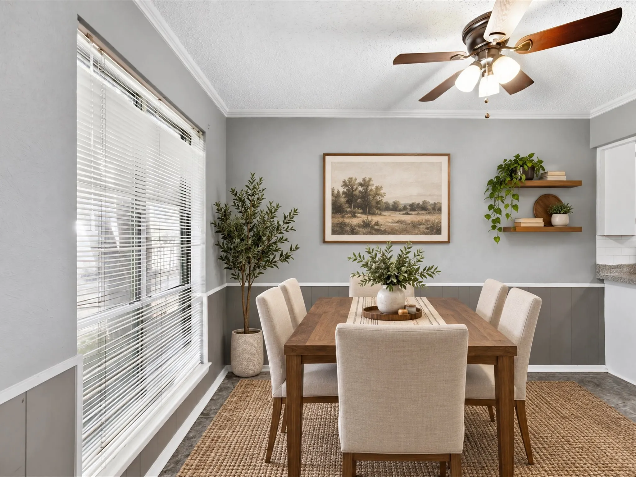 Wall paneling with crown molding, window with blinds, ceiling fan, two wall-mounted floating shelves, and wood-finish flooring