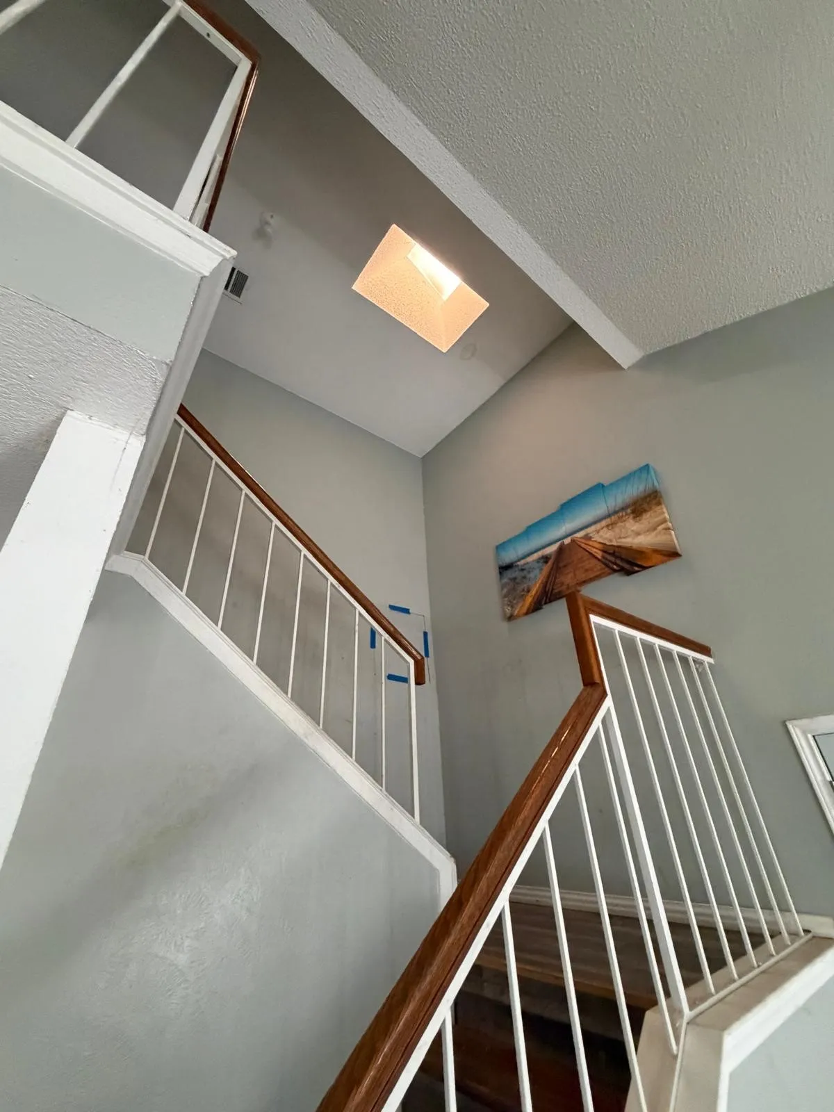 Wood-finish stair treads with white risers and white vertical balusters