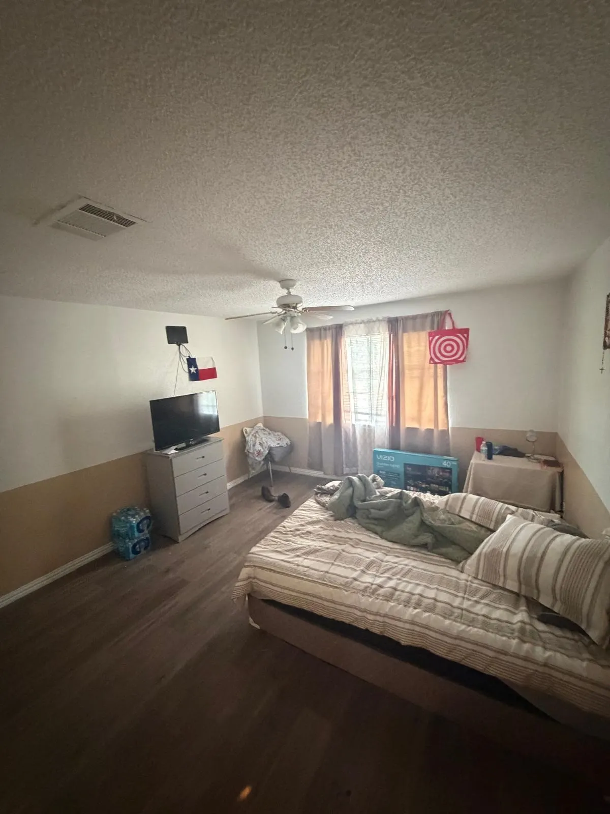 Wood-finish flooring, textured ceiling, ceiling fan, and window