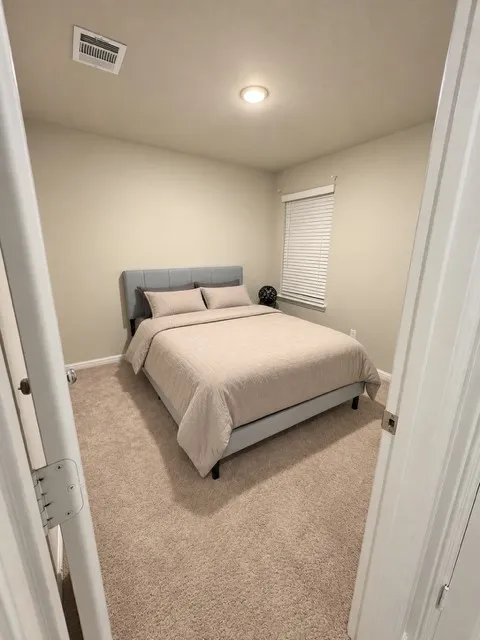 Plush carpeting, recessed lighting, window blinds, and light neutral wall paint