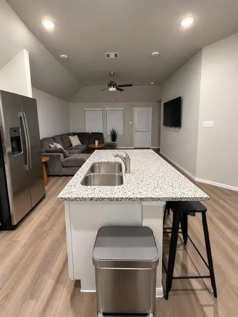 Kitchen island with a double basin sink and speckle-patterned countertop