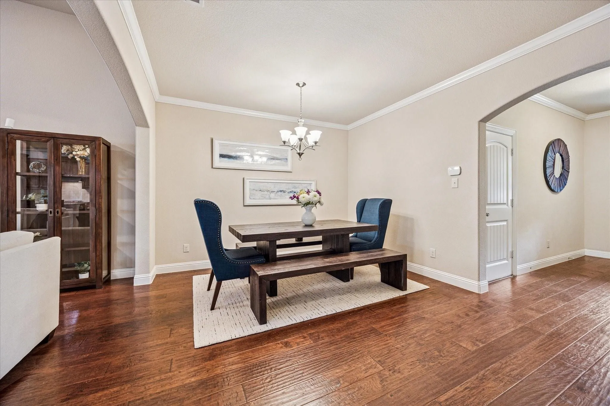 Hardwood flooring, crown molding, cased entryways, recessed lighting, and a built-in display cabinet