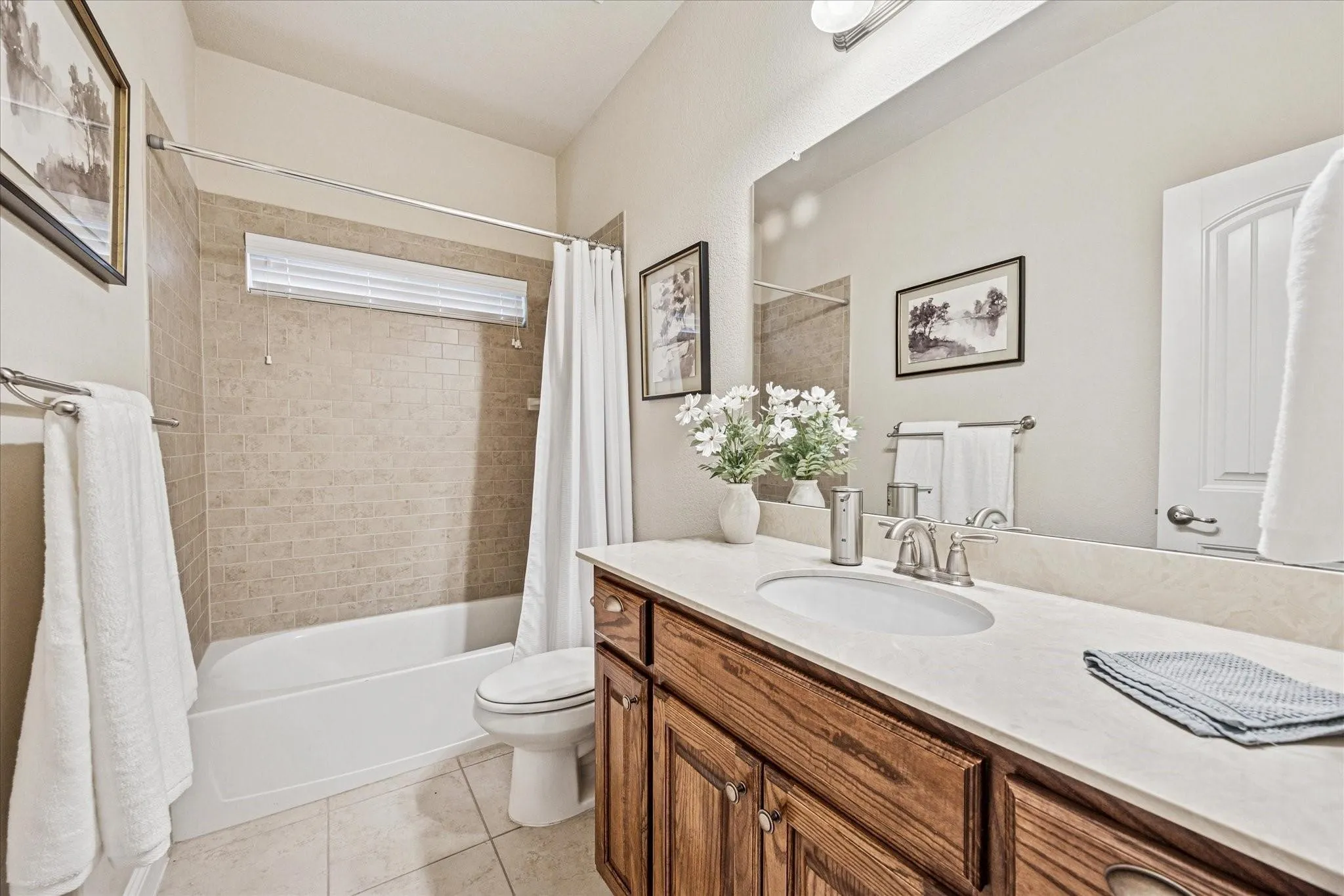 Built-in wood-finish vanity with an undermount sink and light-toned countertop