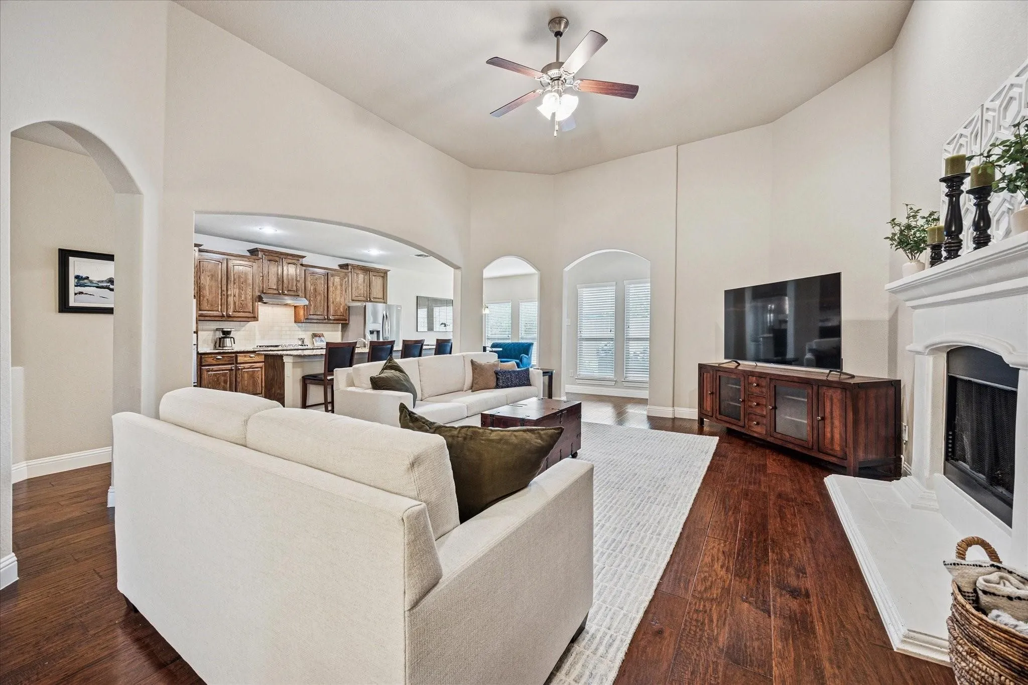 Hardwood flooring throughout, vaulted ceilings, and an arched entryway
