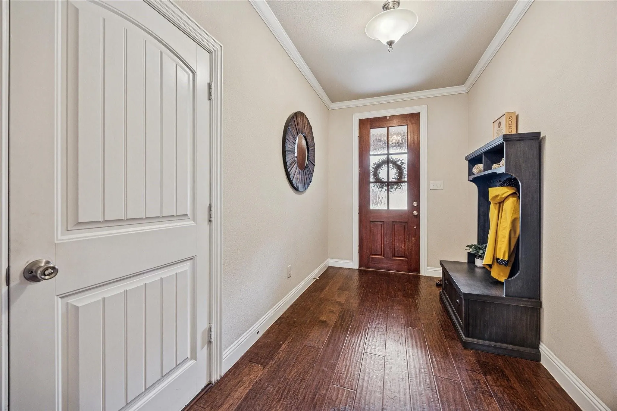 Wood-finish flooring, white trim, recessed lighting, and a solid wood front door with frosted glass panels
