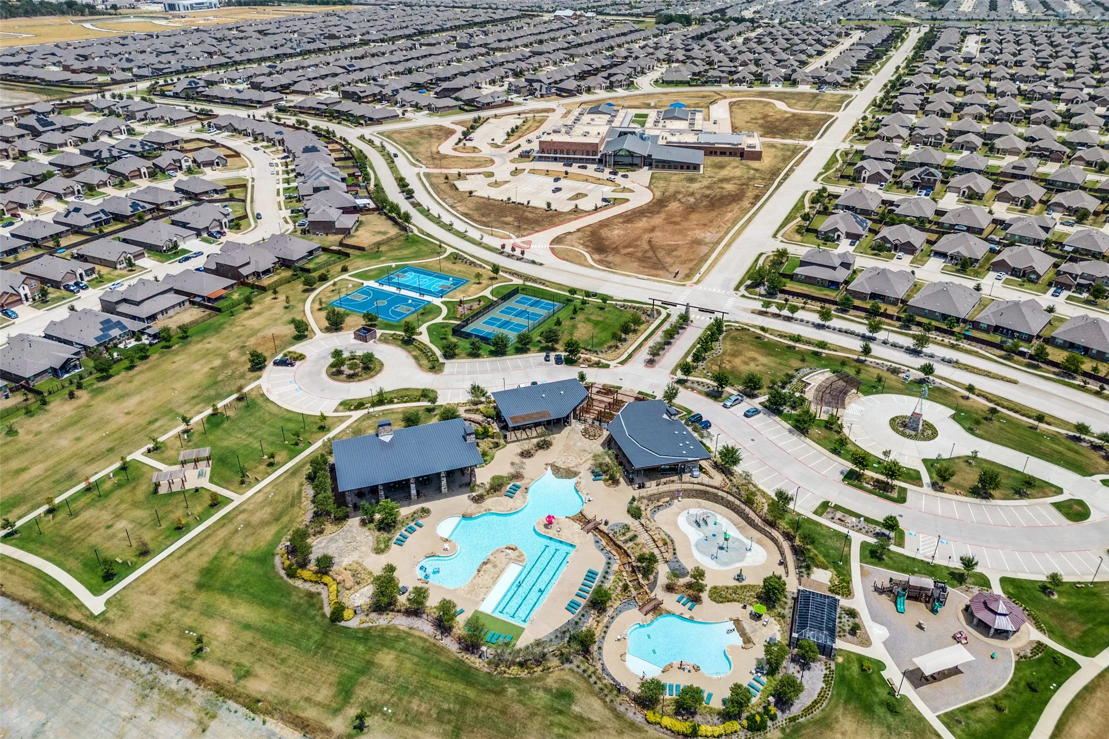 Community features multiple swimming pools, sports courts, a playground, and green spaces, surrounded by residential properties