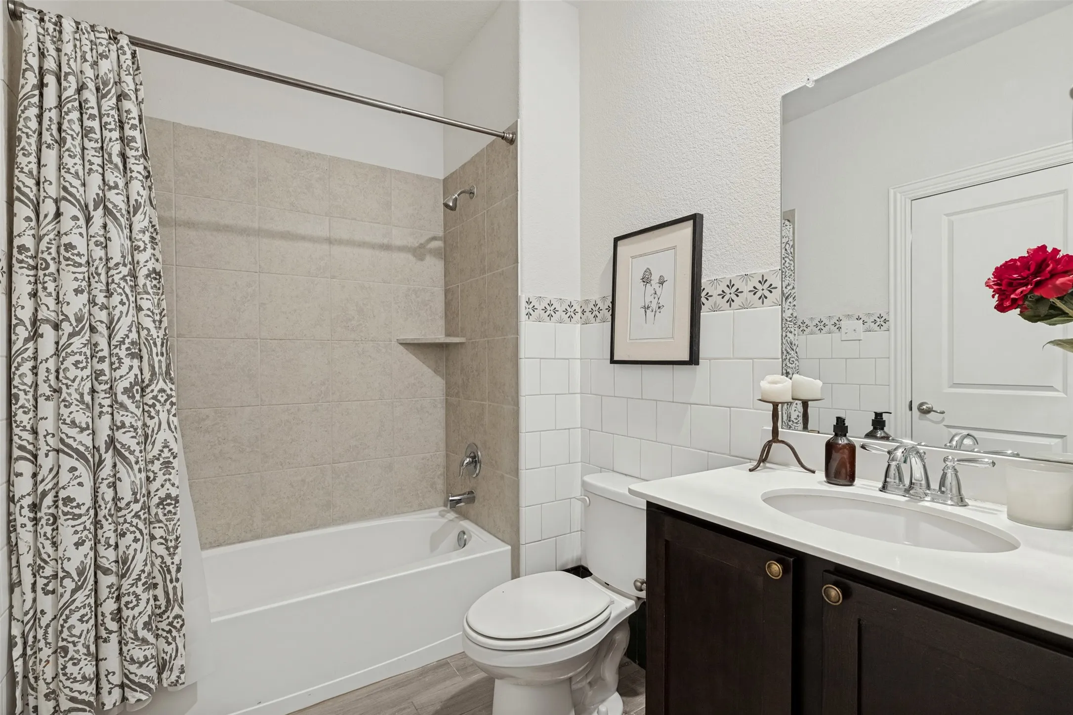 Bathtub with light-toned wall tile surround and integrated shelf