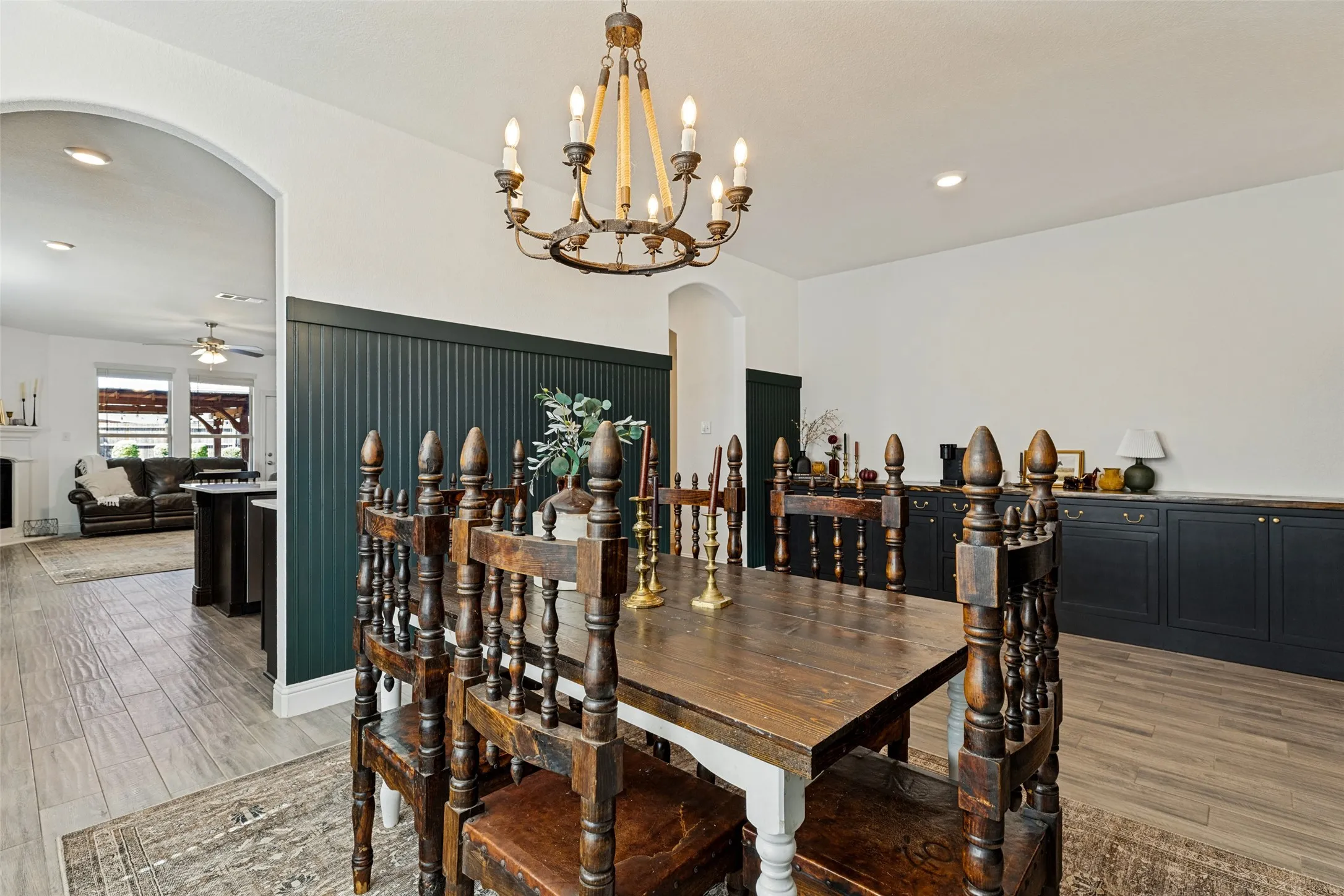 Dining area featuring a wood-finish flooring, an arched doorway, a decorative chandelier, and built-in cabinetry with a wood-finish countertop