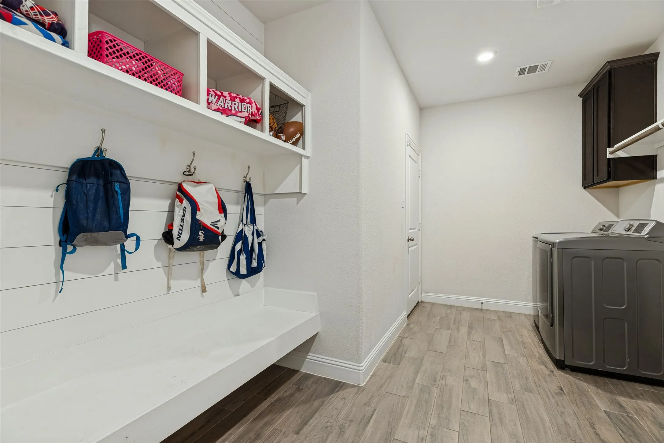 Built-in organizational shelving, integrated bench seating, and wood-finish flooring