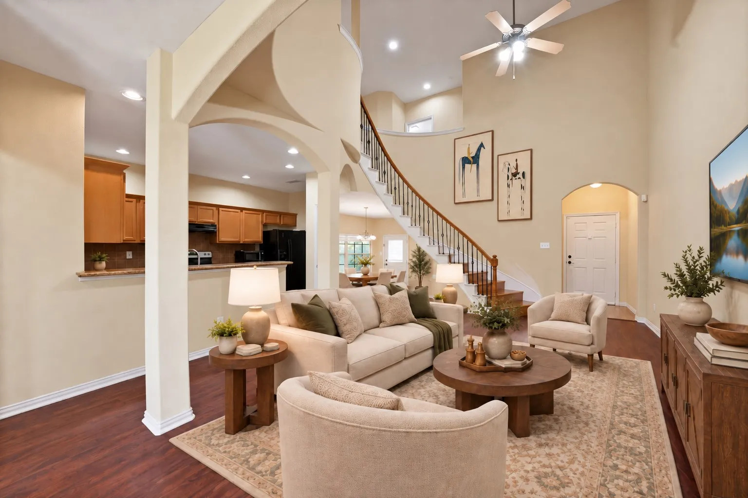 Arched openings and a decorative column frame the living room. Breakfast bar and hallway access to the main level.