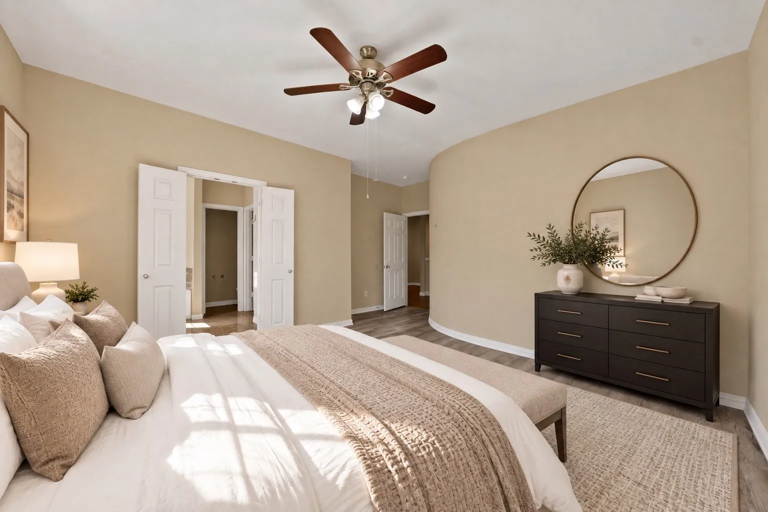 Upstairs primary bedroom with ensuite bathroom - virtually staged Ceiling fan, wide window with blinds, and wood-look flooring. Double doors on the right side of the room.