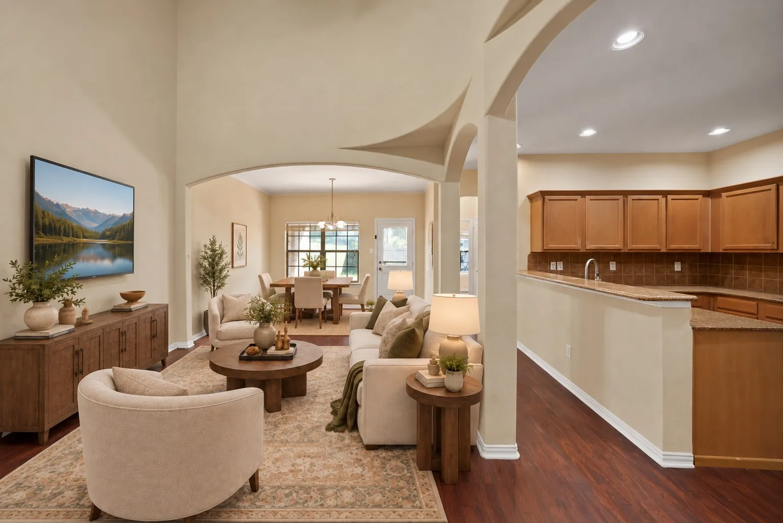 Living room: Two-story ceiling, arched openings, and decorative column. Open to the kitchen breakfast bar and dining area. virtually staged