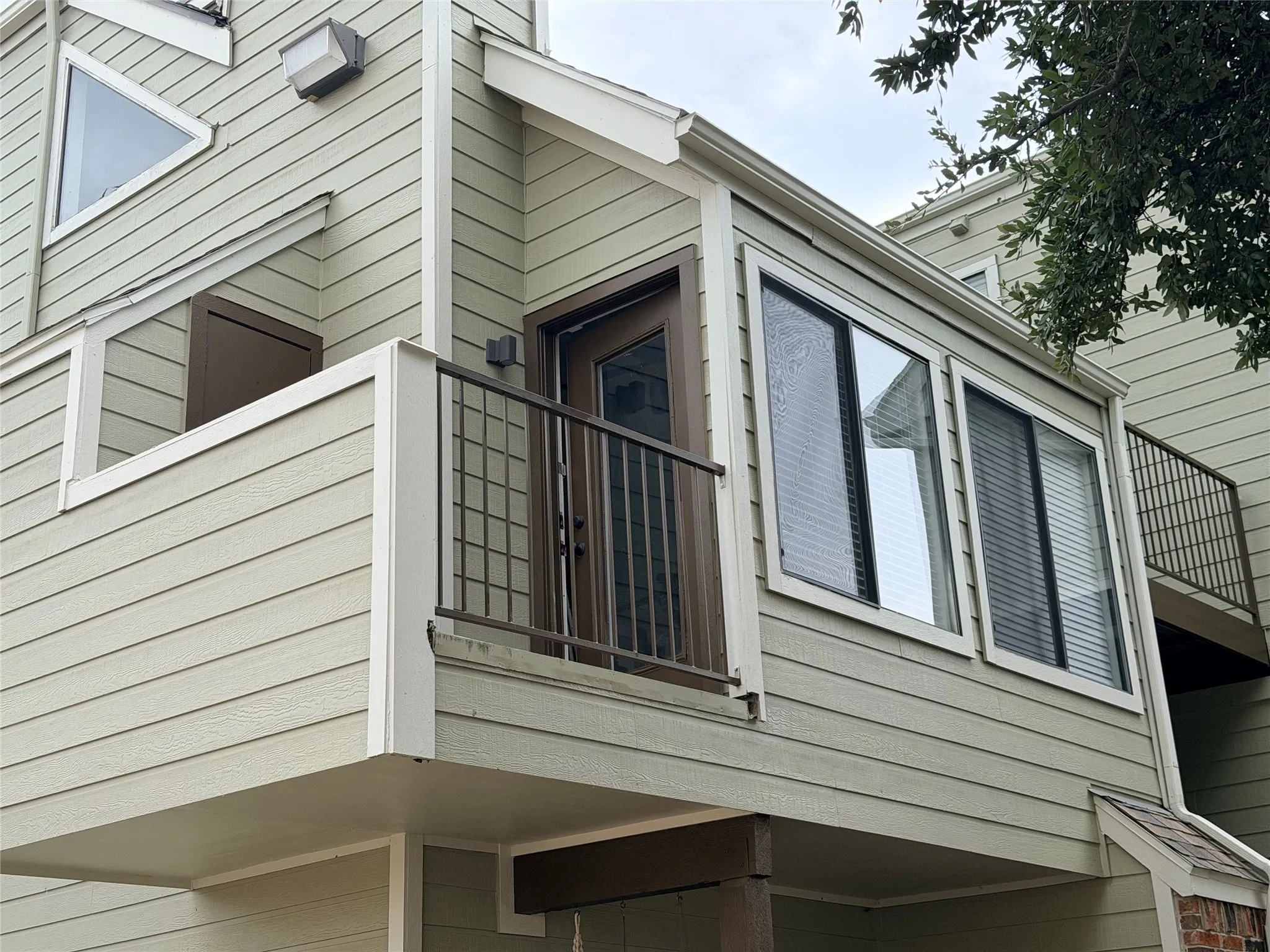 Horizontal siding exterior with a private balcony featuring a metal railing