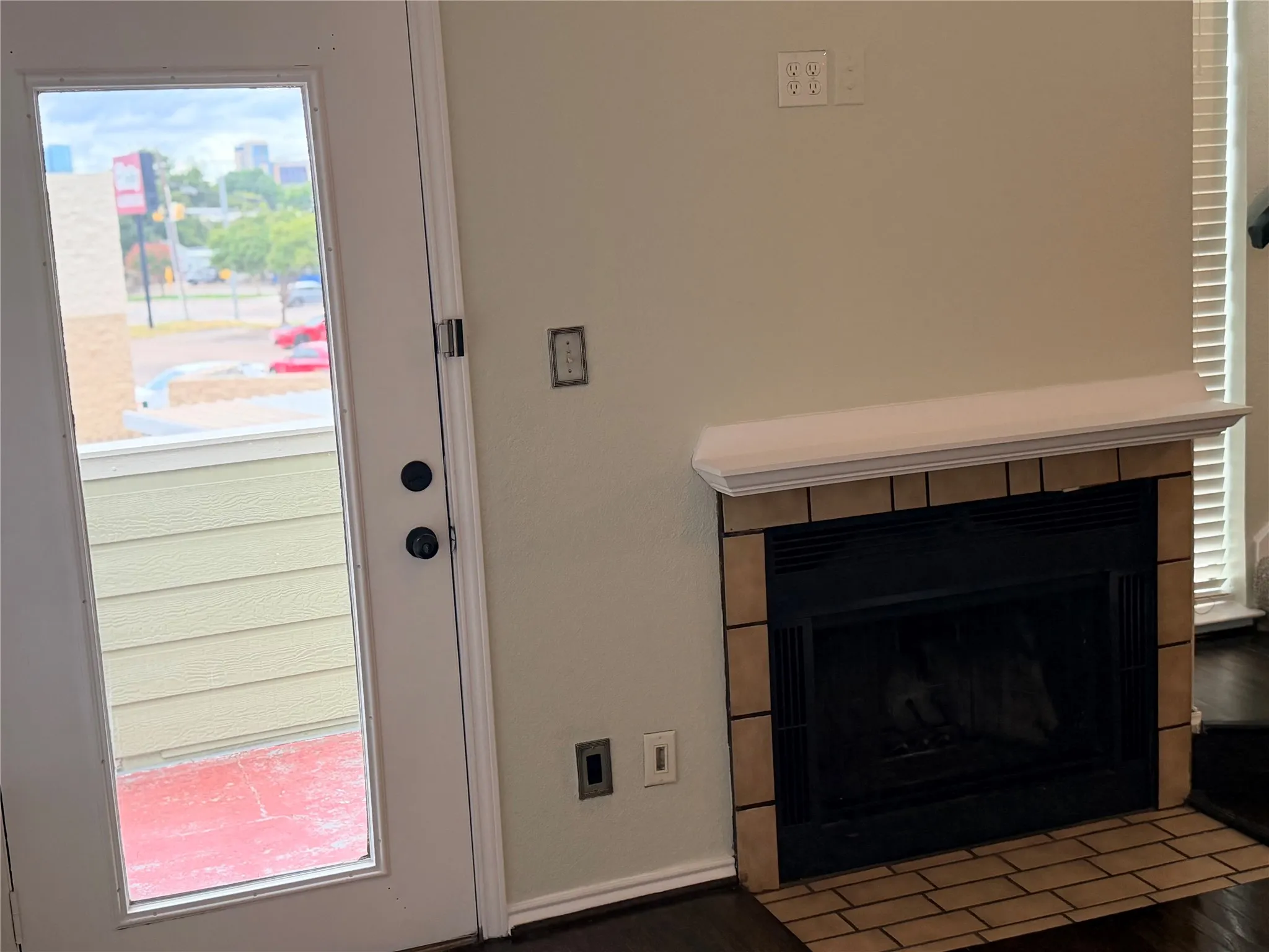 Fireplace with tile surround, white mantel, and dark wood-finish flooring