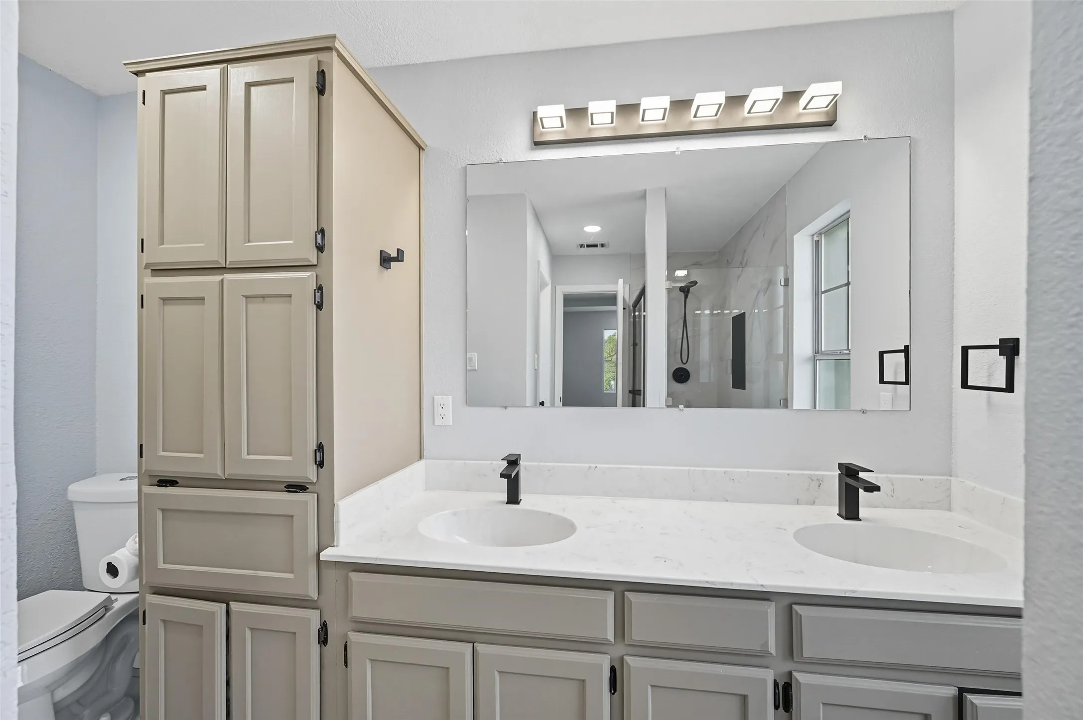 Remolded Primary Bathroom includes duel sinks, cabinets, remolded shower and walk in closet.