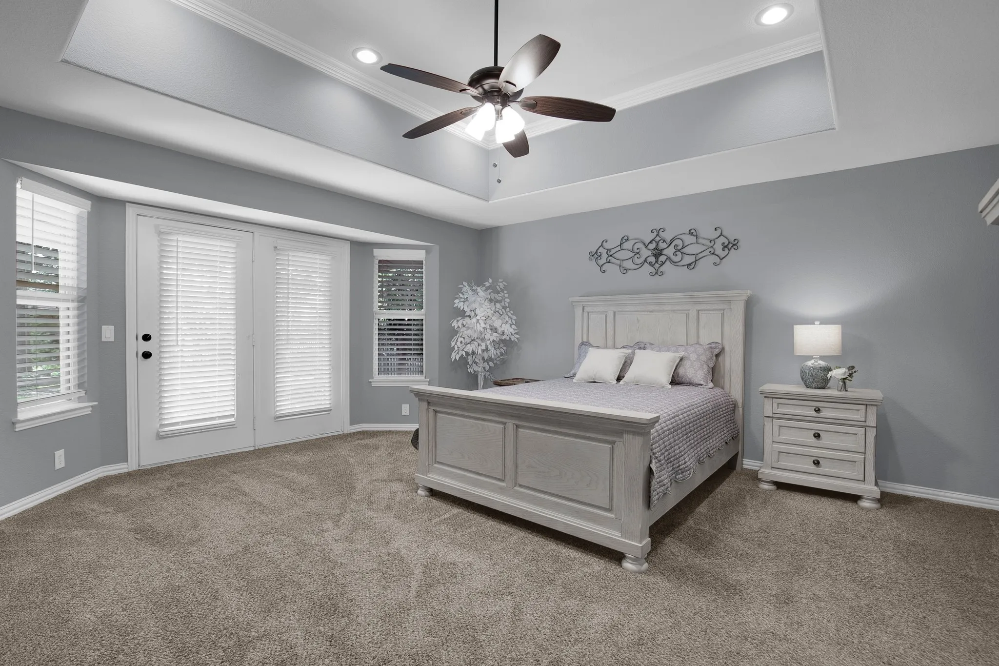 Tray ceiling with recessed lighting and a ceiling fan and patio access for your morning coffee