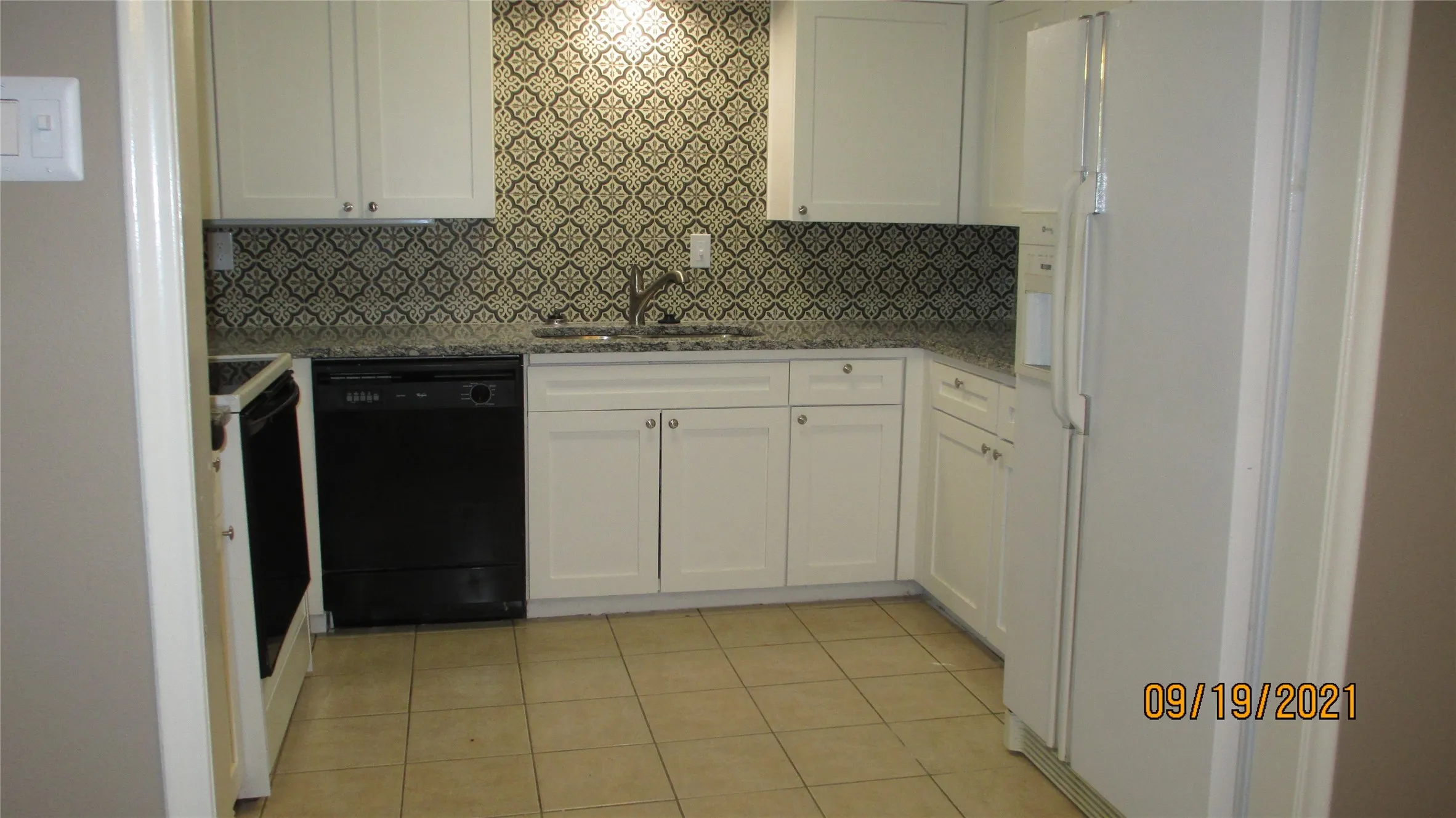 Kitchen with Maytag refrigerator designer backsplash