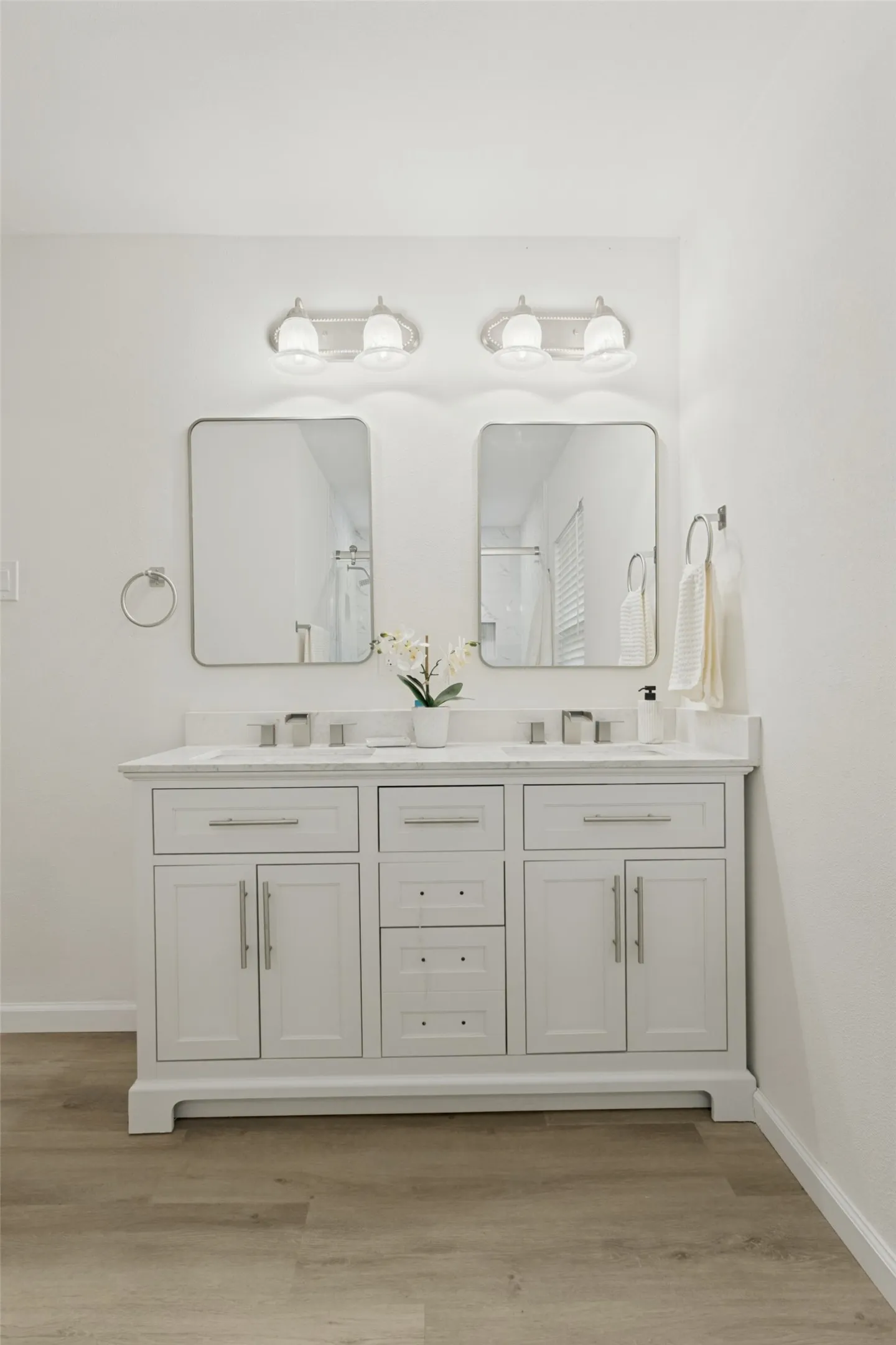 Dual vanity with white cabinetry, rectangular undermount sinks, and a light-toned countertop