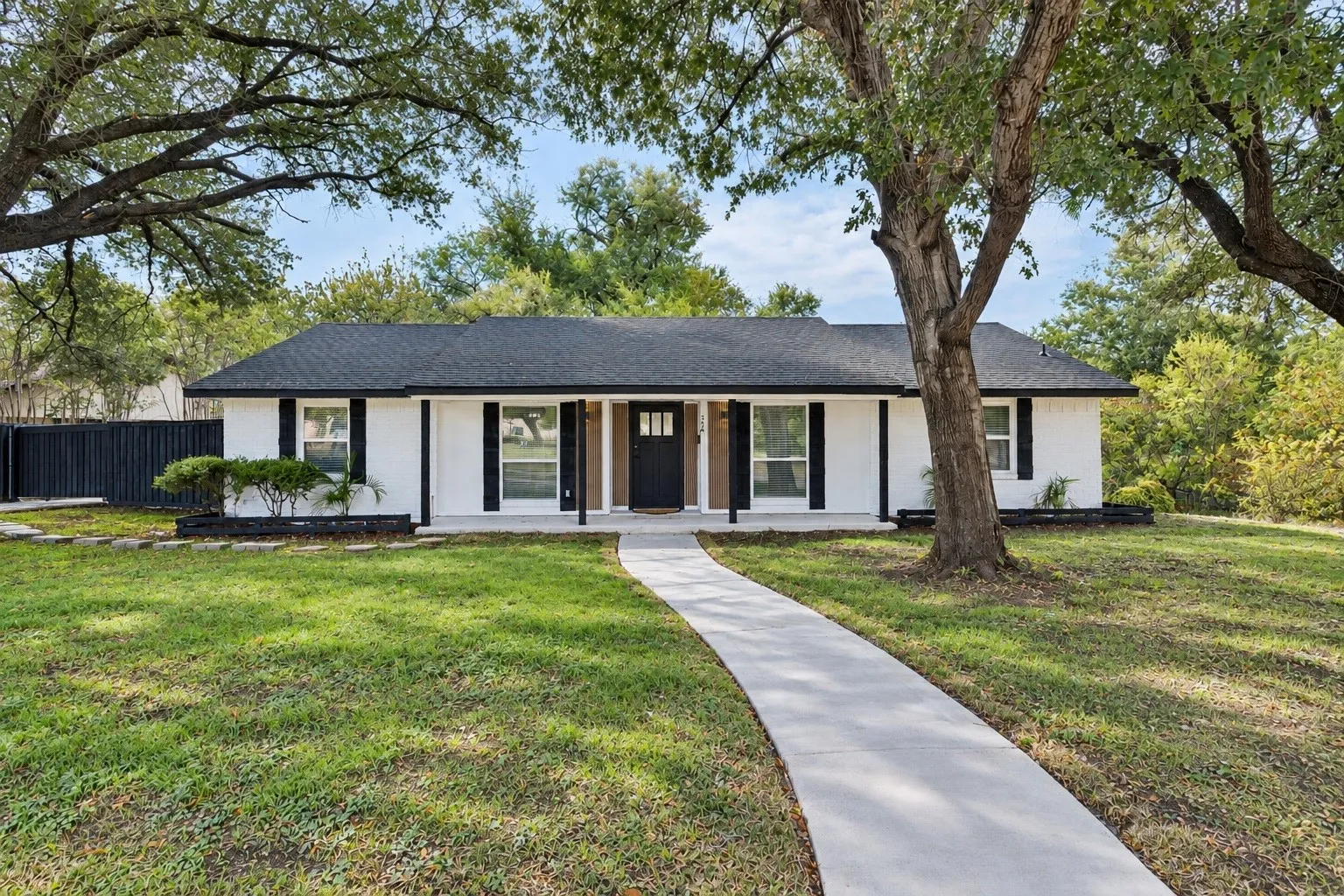White exterior with black shutters and a dark shingle roof