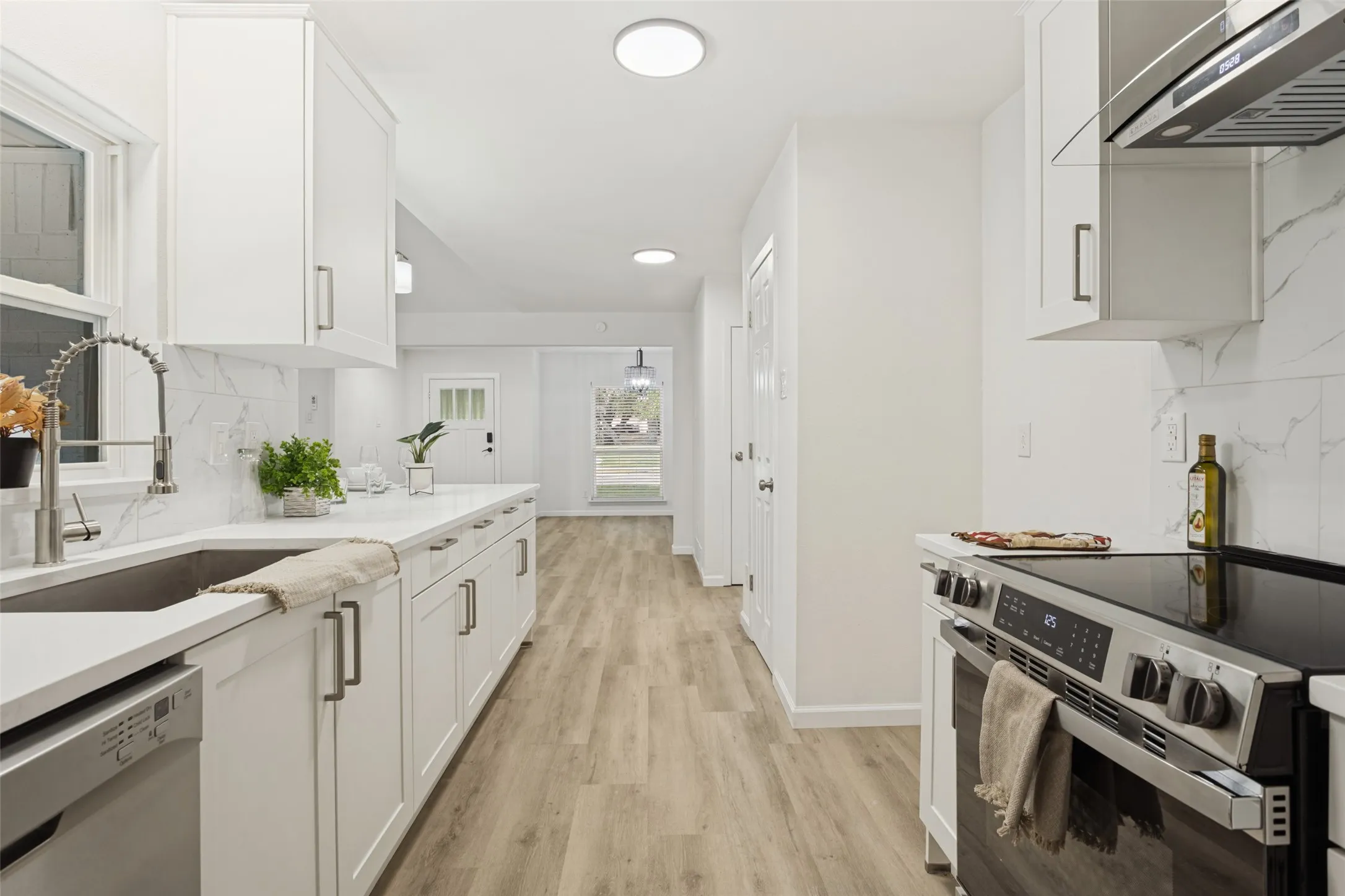 Modern kitchen with white cabinetry and stainless steel appliances