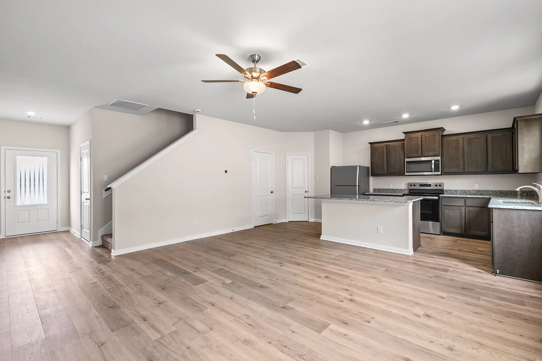 Kitchen featuring dark brown cabinetry, recessed lighting, a center island, appliances with stainless steel finishes, and light wood finished floors