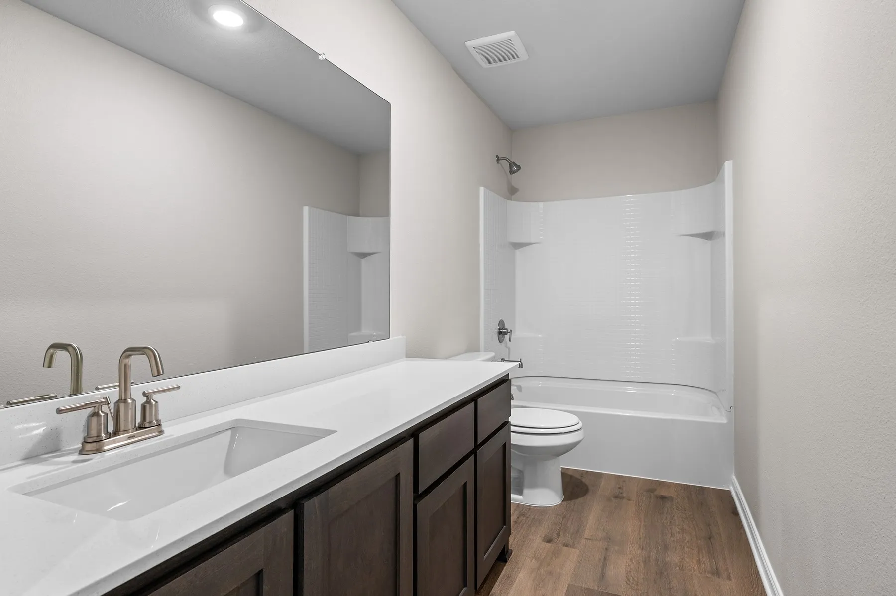 Bathroom featuring shower / bath combination, vanity, and dark wood finished floors