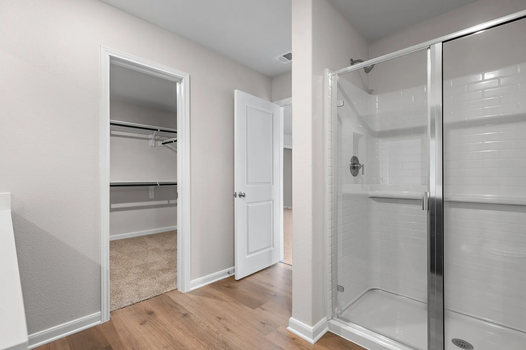 Bathroom featuring a stall shower, light wood-style floors, and a spacious closet