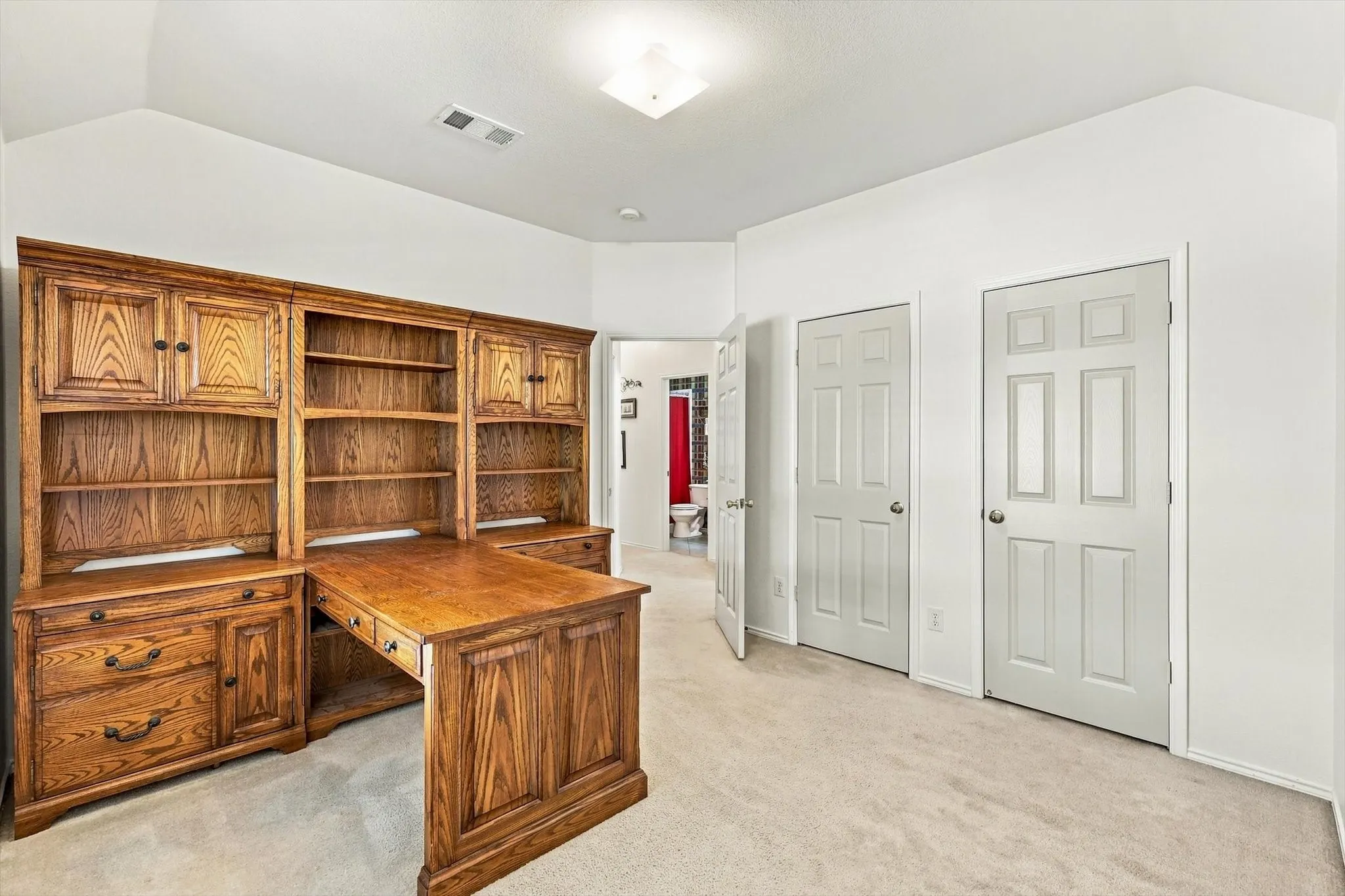 Built-in wood-finish desk with integrated shelving and cabinetry