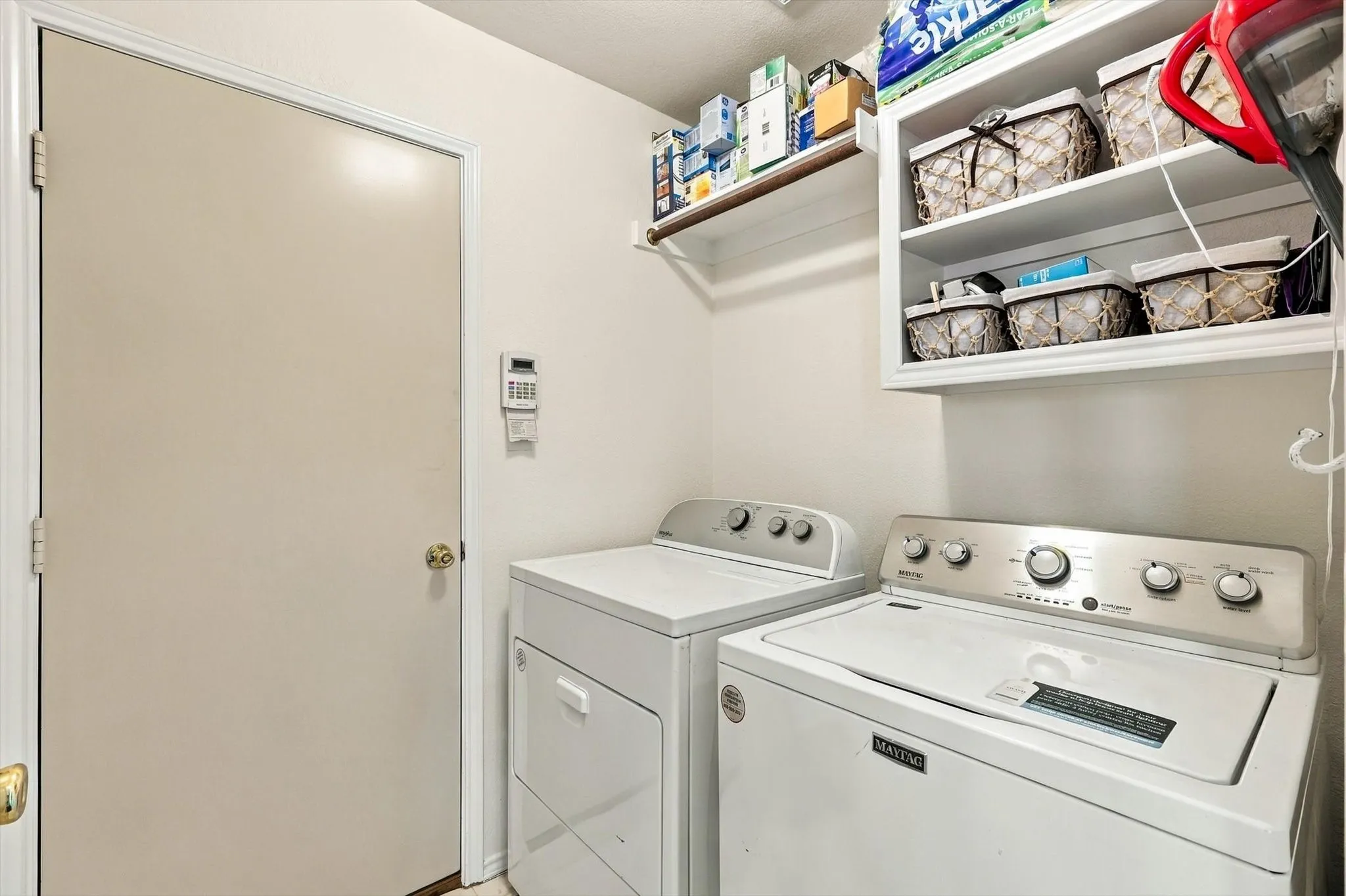 White cabinetry, open shelving, and a wall-mounted clothing rod